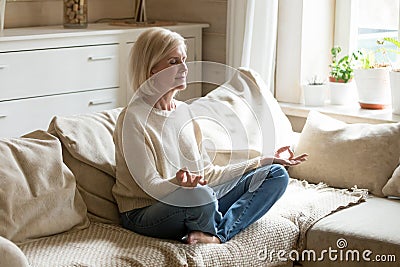 Mindful healthy mature woman practicing yoga meditation at home Stock Photo