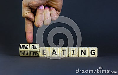 Mindful or intuitive eating symbol. Doctor turns cubes and changes words intuitive eating to mindful eating. Beautiful grey Stock Photo