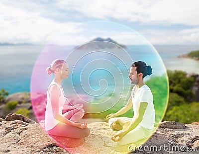 Couple doing yoga in lotus pose with rainbow aura Stock Photo