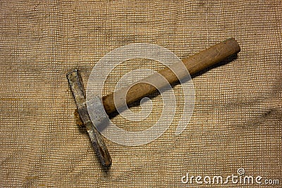 Miner hammer like pickaxe or mattock on bagging fabric background. Closeup view of rustic old hand tool for hard working to Stock Photo