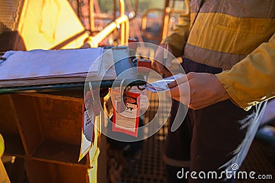 Miner supervisor checking names on the isolation permit lock box to ensure recipients are locking into correct permit box Stock Photo
