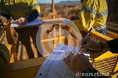 Miner supervisor sigh of JSA risk assessment permit to work on site prior to performing high risk work on construction Stock Photo