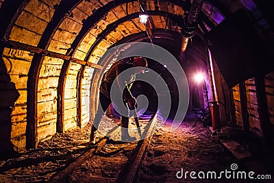 Miner working a jackhammer in a coal mine. Work in a coal mine. Portrait of a miner. Stock Photo