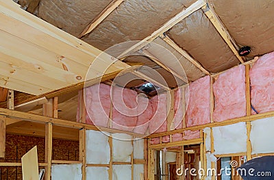 Mineral glass wool in a wooden frame on a inclined wall near the wooden ceiling in a private house Stock Photo