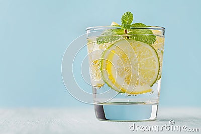 Mineral infused water with limes, lemons, ice and mint leaves on blue background, homemade detox soda water Stock Photo