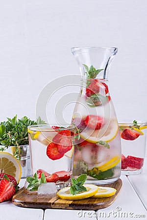 Mineral infused water with strawberry, ice, herb and mint leaves on white background Stock Photo