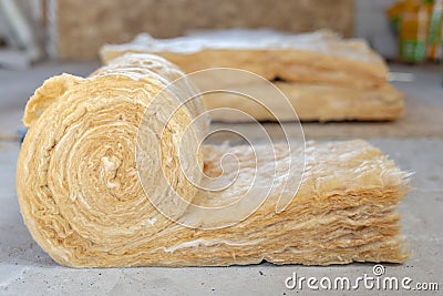 Mineral rockwool lying on attic floor inside house under construction Stock Photo