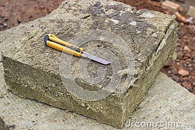 Mineral rockwool panel with a craft knive Stock Photo