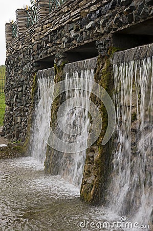 Mineral spring. Stream in the SPA. Curative water. Resort. Waterfalls. Summer. Clear and fresh water on the stone wall Stock Photo