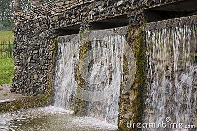 Mineral spring. Stream in the SPA. Curative water. Resort. Waterfalls. Summer. Clear and fresh water on the stone wall Stock Photo