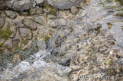 Mineral spring. Stream in the SPA. Curative water. Resort. Waterfalls. Summer. Clear and fresh water on the stone wall Stock Photo