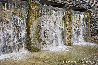 Mineral spring. Stream in the SPA. Curative water. Resort. Waterfalls. Summer. Clear and fresh water on the stone wall Stock Photo