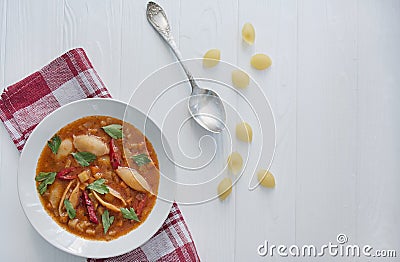 Minestrone soup with pasta and herbs. Italian Cuisine. White wood background. Place for text Stock Photo