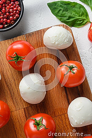 Mini balls of mozzarella cheese, on chop wood board ingredients for salad Caprese. over white background. close up selective focus Stock Photo