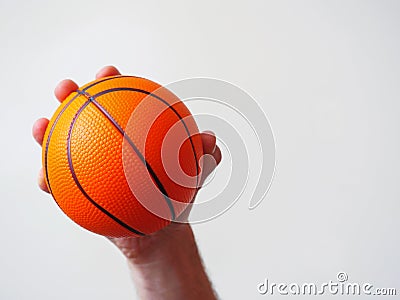 Mini basketball in a hand on a bright background Stock Photo