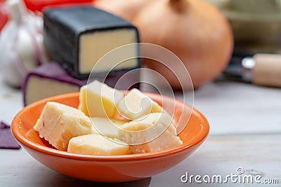 Mini black and dark red waxed cheddar cheeses with strong flavor made from West Country milk and and age-old methods with onion Stock Photo