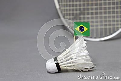 Mini Brazil flag stick on the white shuttlecock on the grey background and out focus badminton racket Stock Photo