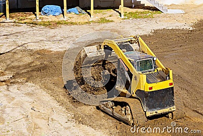 Mini bulldozer working with earth soil while doing landscaping works on construction Stock Photo