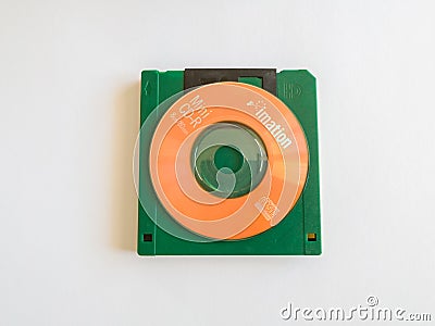 Mini CDs stacked on floppy disks, objects isolated on a white background, the evolution of technology Editorial Stock Photo