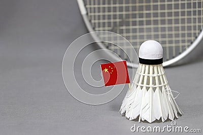 Mini China flag stick on the white shuttlecock on the grey background and out focus badminton racket Stock Photo