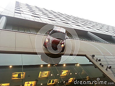 Mini Cooper driving down side of building Editorial Stock Photo