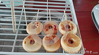 Mini donut on skewers put on a white grill. Stock Photo