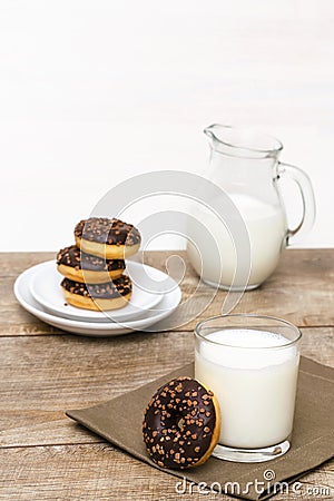 Mini donuts covered with chocolate glaze served with bottle, jug, glass of milk. Stack of tasty sweet sugar creamy or Stock Photo