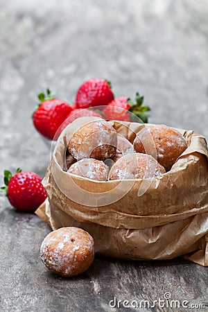 Mini doughnuts stuffed with strawberry jam in paper bag on rust Stock Photo