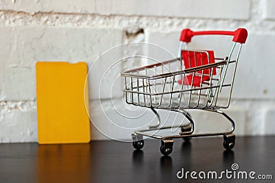 Mini empty shopping cart next to a credit card. Stock Photo
