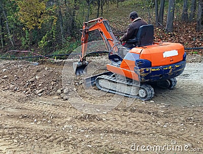 Mini excavator and worker Editorial Stock Photo