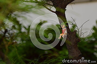 Mini figures sitting on the tree trunks. Stock Photo