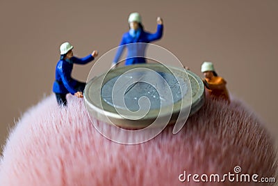 Mini figures and euro coin Stock Photo