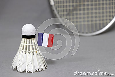 Mini France flag stick on the white shuttlecock on the grey background and out focus badminton racket Stock Photo