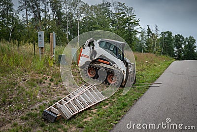 Mini front end loader with forklift attachment at construction site Stock Photo