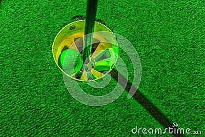 Mini golf ball inside the hole Stock Photo