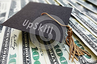 Mini graduation cap with Upskill text on money Stock Photo