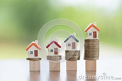 Mini house on stack of coins, Concept of Investment property, Investment risk and uncertainty in the real estate housing market Stock Photo