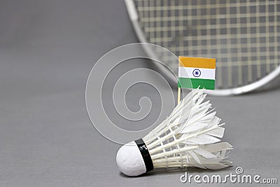 Mini India flag stick on the white shuttlecock on the grey background and out focus badminton racket Stock Photo