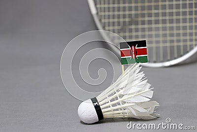 Mini Kenya flag stick on the white shuttlecock on the grey background and out focus badminton racket Stock Photo