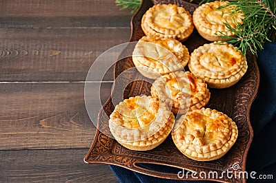 Mini meat pies from flaky dough on a vintage tray over wooden ba Stock Photo