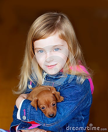 Mini pinnscher puppy mascot with blond kid girl Stock Photo