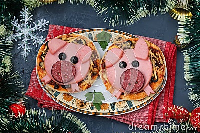 Mini pizza with sausage and cheese in the shape of a cute pigs - a symbol of 2019 Stock Photo