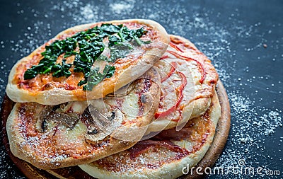 Mini pizzas with various toppings on the wooden board Stock Photo