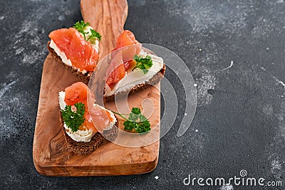 Mini sandwiches with salmon, curd cheese, parsley and rye bread in form of hearts. Valentine`s day homemade creative food. Love Stock Photo