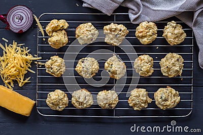 Mini savoury cheese and onion muffins out of oven on cake grid - overhead view of cheesy appetizer biscuit Stock Photo