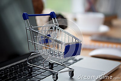 Mini shopping cart on computer laptop. Business concept. Editorial Stock Photo