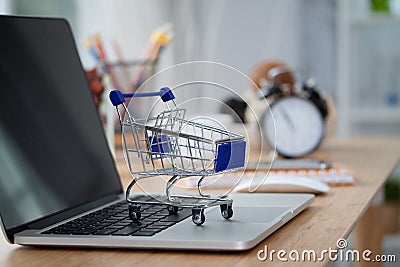 Mini shopping cart on computer laptop. Business concept. Editorial Stock Photo