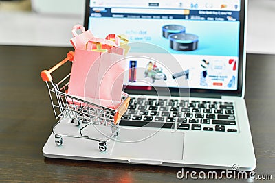 Mini Shopping Cart on Laptop with E-Commerce Website Editorial Stock Photo