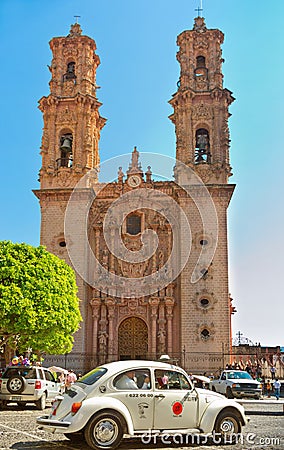 Mini taxi against the Cathedral of Taxco, Mexico. Editorial Stock Photo