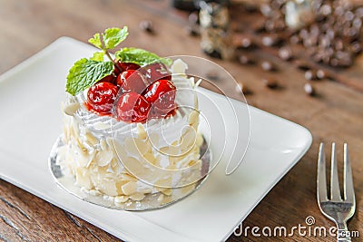 Mini vanilla cream cake with almond and cherry. Stock Photo